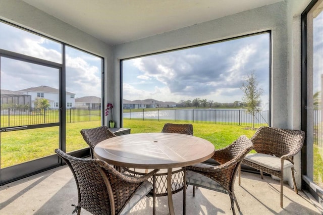 sunroom / solarium with a water view and a residential view