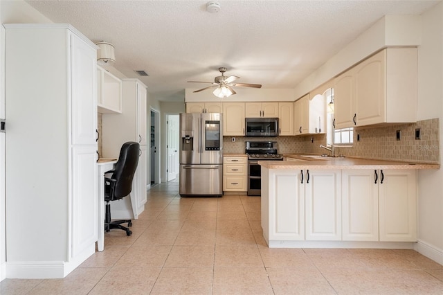 kitchen with stainless steel appliances, a peninsula, a sink, visible vents, and tasteful backsplash