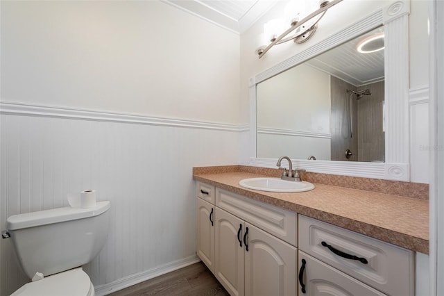 bathroom featuring a shower, wainscoting, toilet, wood finished floors, and vanity