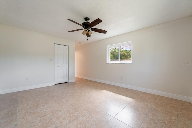 spare room with baseboards and a ceiling fan