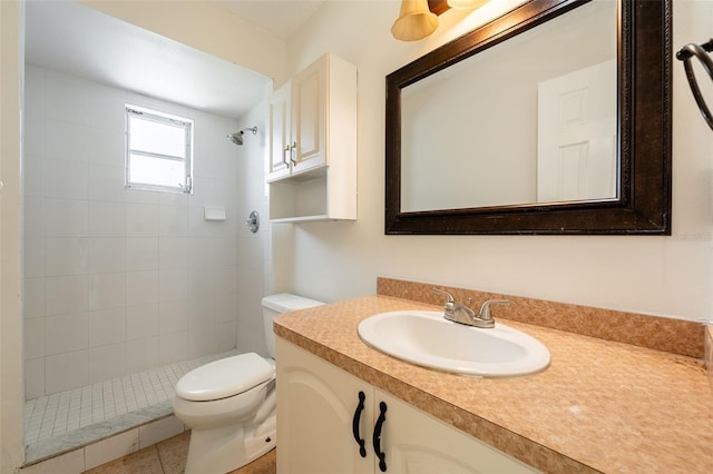 bathroom with tiled shower, vanity, and toilet