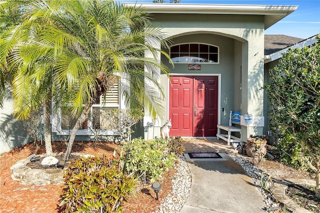 doorway to property featuring stucco siding