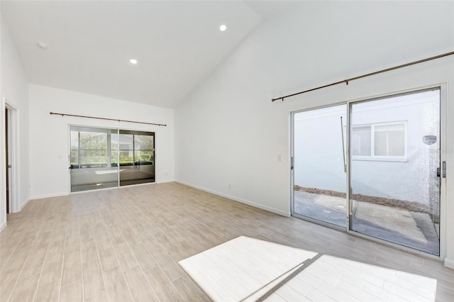 spare room with high vaulted ceiling, light wood-type flooring, baseboards, and recessed lighting