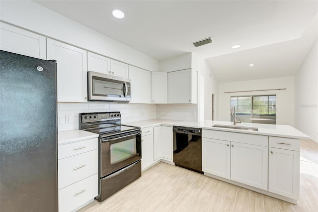 kitchen with visible vents, decorative backsplash, a sink, a peninsula, and black appliances