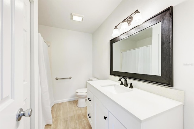 full bath featuring baseboards, vanity, and toilet