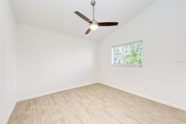 spare room with lofted ceiling, ceiling fan, light wood finished floors, and baseboards