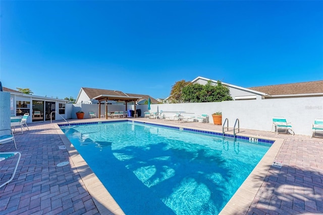 community pool featuring a patio area, fence, and a gazebo