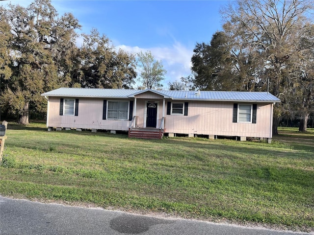 view of front of home with a front yard and metal roof