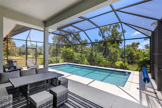 outdoor pool featuring glass enclosure, a patio, and an outdoor hangout area