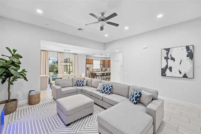 living room with recessed lighting, visible vents, ceiling fan, and baseboards