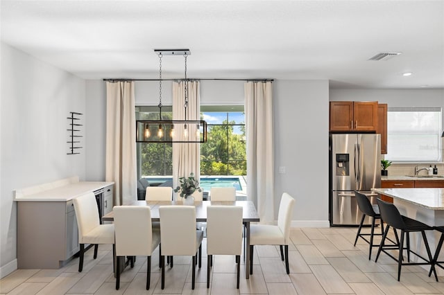 dining area with a chandelier, visible vents, and baseboards