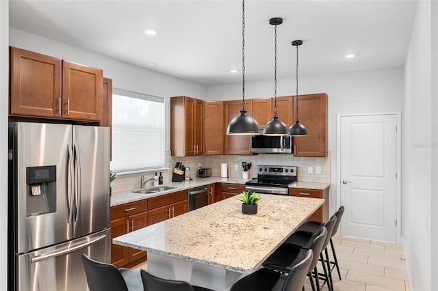 kitchen featuring tasteful backsplash, brown cabinets, a kitchen breakfast bar, stainless steel appliances, and a sink