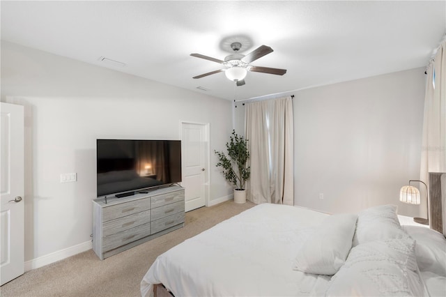 bedroom featuring light carpet, baseboards, and a ceiling fan