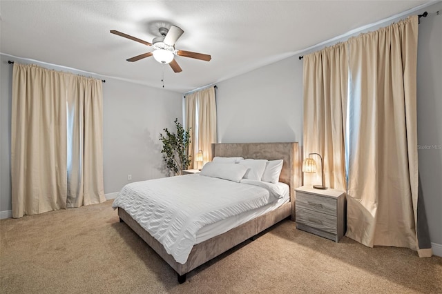 bedroom with baseboards, a ceiling fan, and light colored carpet