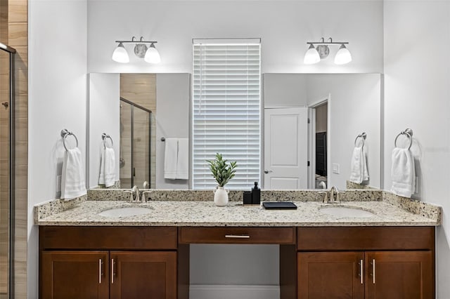 bathroom featuring double vanity, a stall shower, and a sink