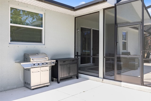 view of patio / terrace featuring a sunroom and a grill