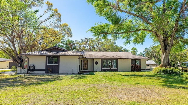 ranch-style home with a front yard, a standing seam roof, and metal roof