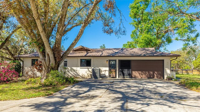 single story home with a garage, driveway, fence, and stucco siding