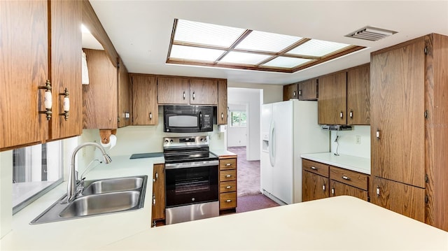 kitchen featuring white refrigerator with ice dispenser, visible vents, stainless steel range with electric stovetop, black microwave, and a sink