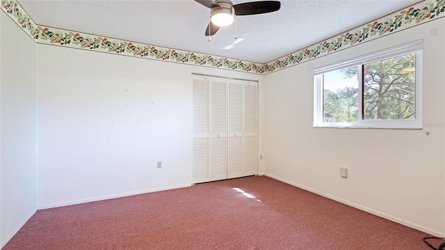 unfurnished bedroom featuring a textured ceiling, carpet floors, a closet, and baseboards