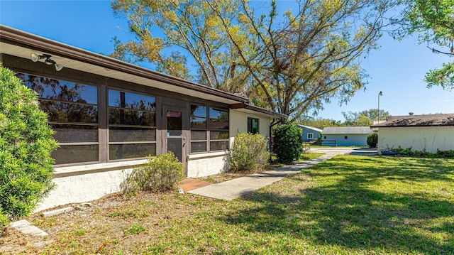 exterior space with a yard and stucco siding