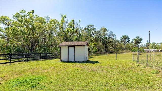 view of yard featuring an outbuilding, a storage unit, and fence