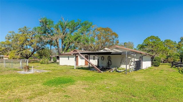 rear view of property featuring a yard and fence