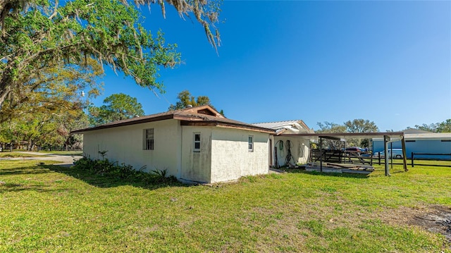 view of home's exterior featuring stucco siding, metal roof, and a yard