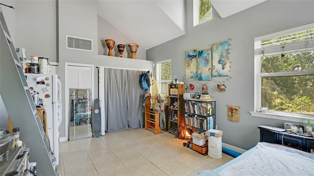 bedroom featuring tile patterned flooring, multiple windows, visible vents, and high vaulted ceiling