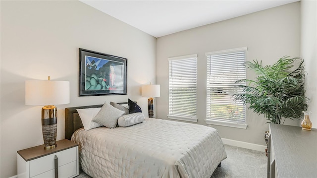 bedroom featuring light colored carpet and baseboards