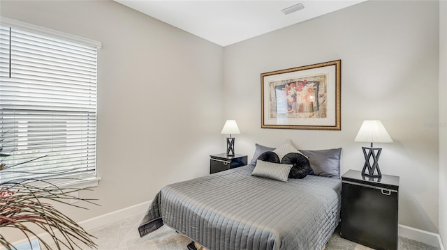 bedroom featuring carpet floors, visible vents, and baseboards