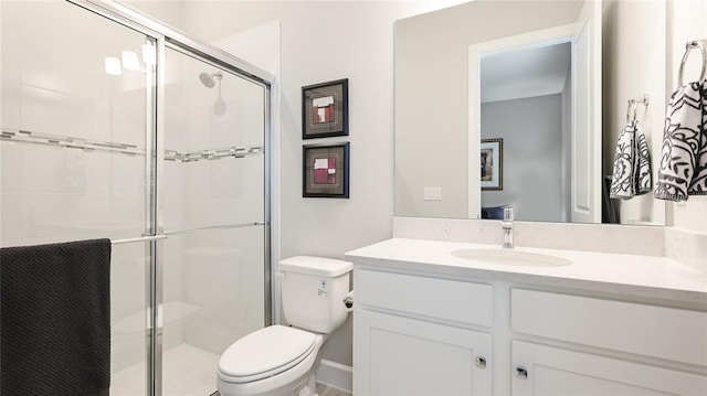 bathroom with vanity, a shower stall, and toilet