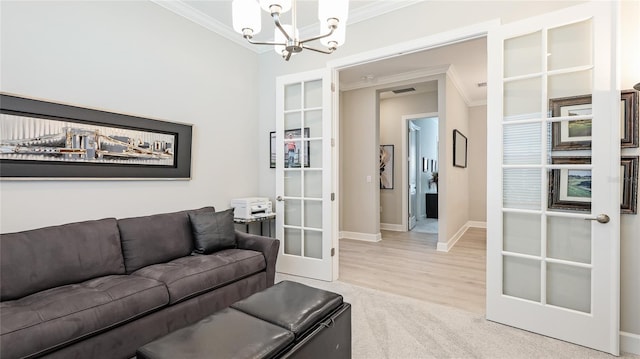 living area featuring baseboards, light wood-style flooring, an inviting chandelier, crown molding, and french doors