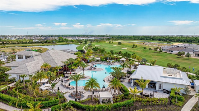 aerial view of a golf course, a pool area, and a nearby body of water