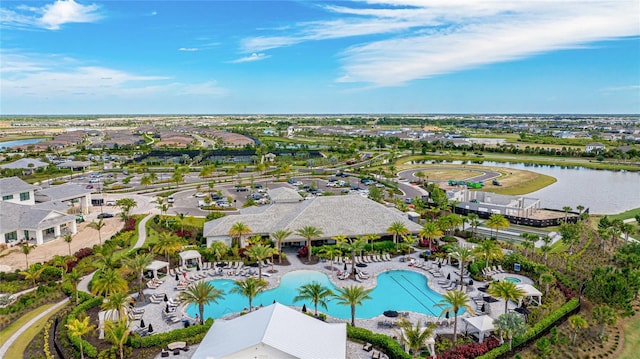aerial view of residential area with a pool and a large body of water