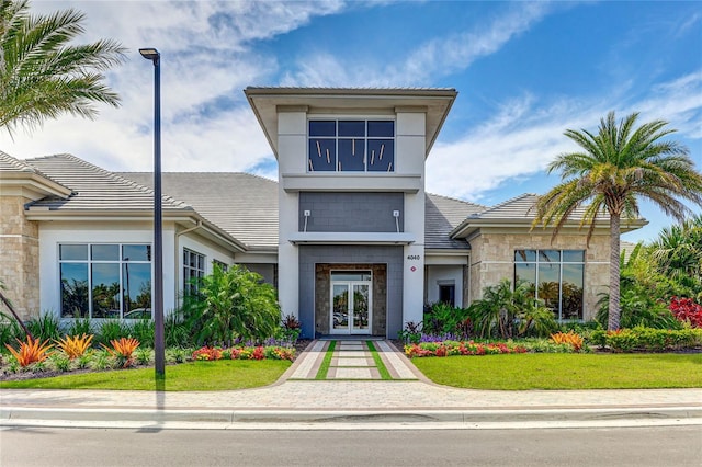 view of front of home featuring stone siding, stucco siding, french doors, and a tiled roof
