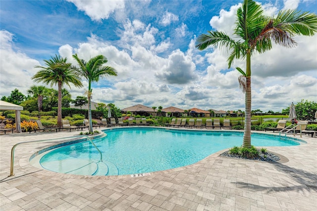 community pool with fence and a patio