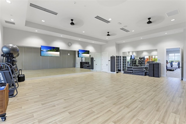 workout area with recessed lighting and light wood finished floors