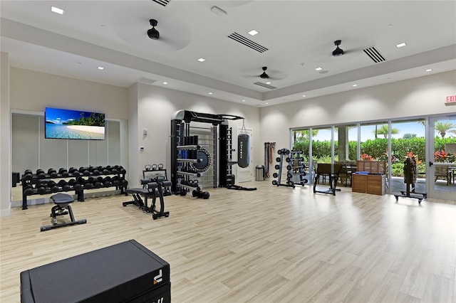 exercise room with a ceiling fan, a high ceiling, wood finished floors, and recessed lighting