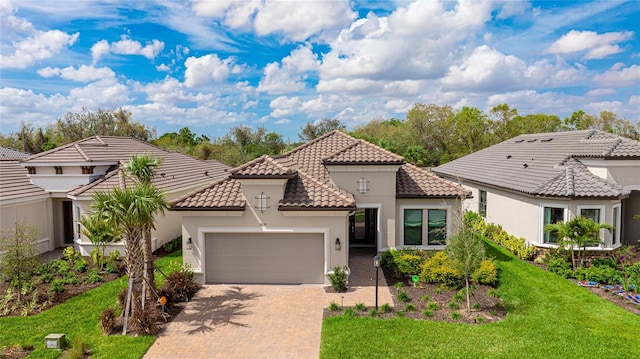mediterranean / spanish-style home featuring a garage, stucco siding, decorative driveway, a tile roof, and a front yard