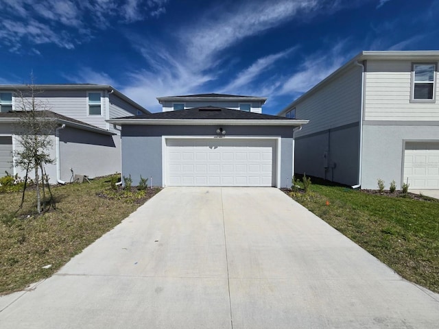 view of front of house featuring driveway, a garage, an outdoor structure, and stucco siding