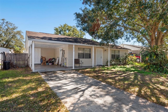 view of front of property with a carport, a front yard, concrete driveway, and fence