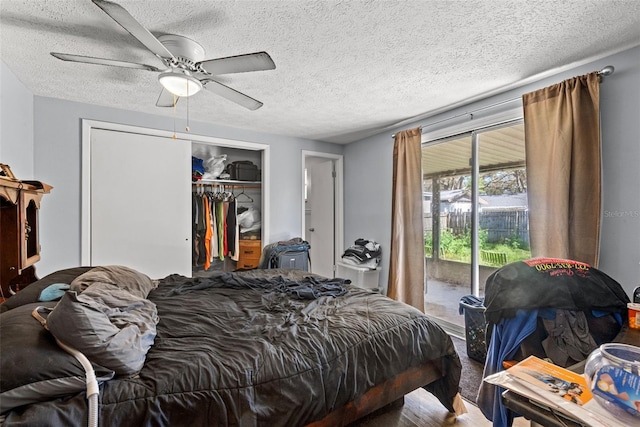 bedroom with ceiling fan, access to outside, a closet, and a textured ceiling