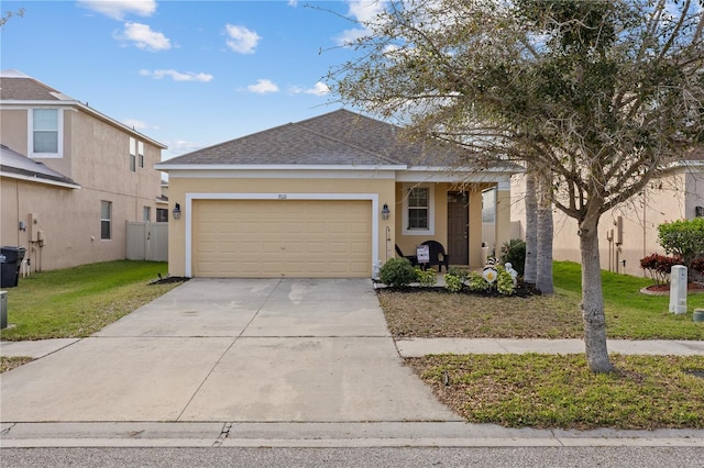 ranch-style home with driveway, a garage, a shingled roof, stucco siding, and a front yard