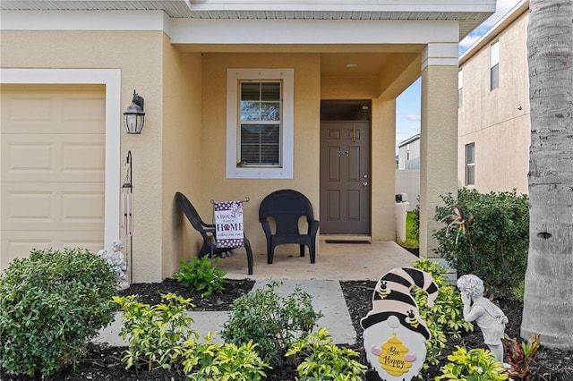 property entrance with an attached garage and stucco siding