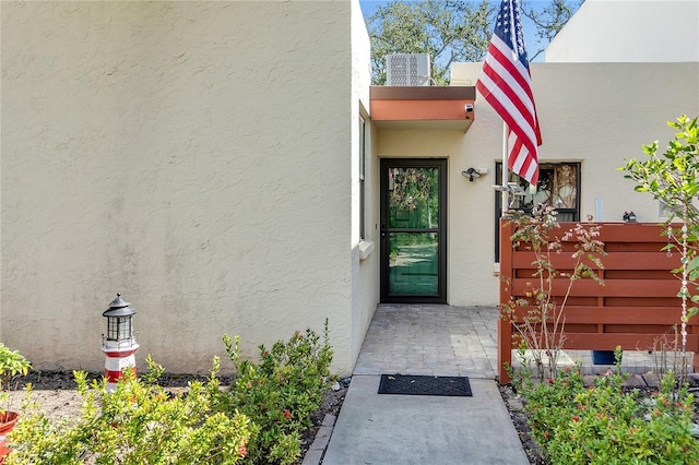 doorway to property featuring stucco siding