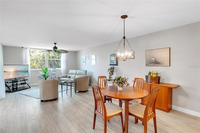 dining area featuring baseboards, ceiling fan, and light wood finished floors