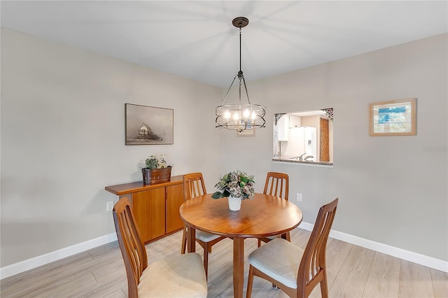 dining space with light wood-style flooring and baseboards