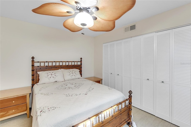 bedroom with light carpet, a closet, visible vents, and a ceiling fan