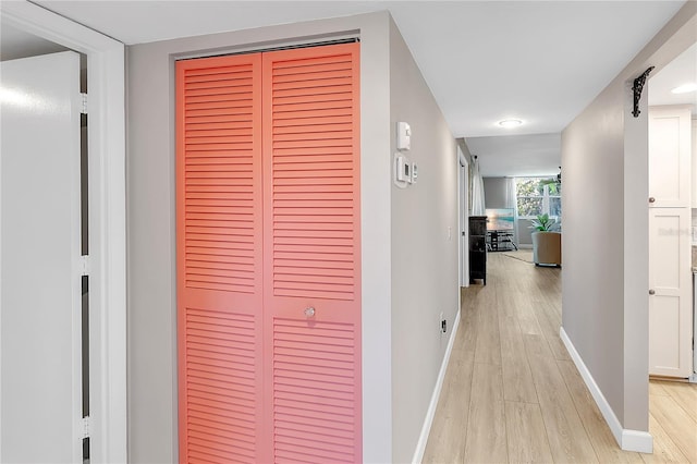 hallway featuring light wood-type flooring and baseboards